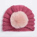 Gros plan détaillé du bonnet tricoté rose foncé pour bébé avec pompon en fausse fourrure douce - Rose Poudré