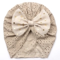 Detail der Baby-Turban-Mütze mit hohlem Strickmuster und goldener Punktschleife - Kaffeebraun