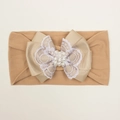 Détail d'un bandeau bébé avec gros nœud, dentelle blanche et décoration en perles - Café Clair