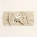Dettaglio della fascia per neonati in velluto oro champagne con grande fiocco fatto a mano - Beige