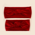 Détail de bandeaux en velours rouge avec nœud pour maman et bébé sur fond beige - Rouge