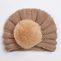 Détail du bonnet turban tricoté pour bébé en marron avec grand pompon en fourrure - Café