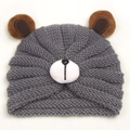 Close-up of gray knit baby bear hat with plush brown ears and soft winter textures - Gray