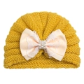 Detail einer gelben Baby-Strickmütze mit Spitzenschleife und Zierperlen - Gelb