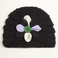 Gros plan détaillé d'un bonnet bébé en tricot noir avec fleur et bouton vert - Noir