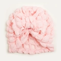 Close-up of light pink popcorn fabric baby turban with a large decorative bow - Snow Bud