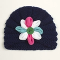 Detailed close-up of dark blue knitted baby turban with large colorful fabric flower detail - Navy Blue