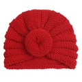 Detail of red knit donut turban hat showing thick yarn texture and radial pleats - Red