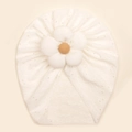 Detailed view of cream baby turban with yellow flower center and eyelet hollow pattern - White
