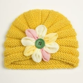Detail of baby yellow knit turban hat featuring colorful fabric flower and green button - Yellow