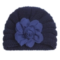 Gros plan sur un bonnet tricoté bleu marine pour bébé avec une grande fleur en tissu texturé - Bleu Marine
