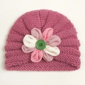 Detailed knit texture of a rose pink baby hat featuring a 3D floral accent and green button - Dusky Pink