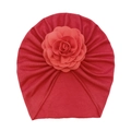 Close-up of red soft knit baby turban hat with large decorative 3D rose flower detail - Red