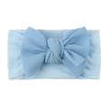 Dettaglio macro della fascia neonata celeste con fiocco morbido a trama waffle - Blu