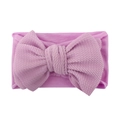 Dettaglio fascia per neonati in tessuto a nido d'ape con grande fiocco in rosa-viola - Viola
