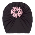 Detail of baby turban hat featuring a pink polka dot fabric flower and pleated knit - One Size / Black