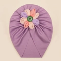 Dettaglio del turbante per neonati con fiore di stoffa multicolore e bottone verde centrale - Viola