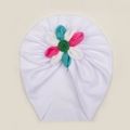Dettaglio del turbante per neonati che mostra il tessuto a coste e il fiore colorato - Bianco