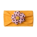 Detail of baby headband featuring large pink polka dot flower on yellow elastic band - Earthy Yellow
