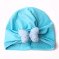 Detail of baby blue turban hat featuring soft knitted fabric and a quilted bow design - Blue