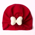 Detail of red baby turban hat with a large white bow on soft ribbed cotton fabric - Red