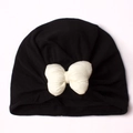 Detailed view of black newborn turban hat with a large white decorative bow knot - Black