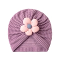 Detail der Baby-Turbanmütze aus violettem Waffelstoff mit einer rosa 3D-Blumenverzierung - Lila