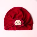 Close-up of red cotton baby beanie featuring a cute cartoon lion patch and wavy edges - One Size / Red