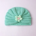 Gros plan du bonnet tricoté vert menthe pour bébé avec fleur au crochet faite main - Vert menthe