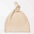 Detalle de la textura acanalada y costuras de un gorro beige con nudo para bebé - Café Claro