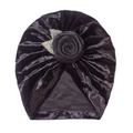 Detailaufnahme des schwarzen Baby-Turbans aus Samt mit Rosenblüte und Metallblättern - Schwarz