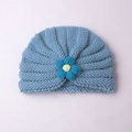 Gros plan d'un bonnet tricoté bleu clair pour bébé avec plis et décor floral jaune et bleu - Bleu