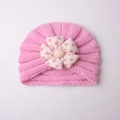 Pink baby knitted turban hat featuring a cute polka dot fabric flower accessory - Pink