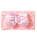 Detail van een roze baby haarband met een grote satijnen strik en elastische stof - Roze