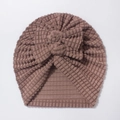 Detail of baby beanie featuring waffle texture fabric and a large decorative bow - One Size / Coffee