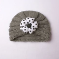 Dark grey knitted baby hat featuring a large white polka dot flower and black center button - Gray