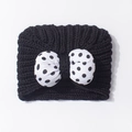 Detail einer dicken schwarzen Baby-Strickmütze mit 3D-Schleife und weißen Punkten - Einheitsgröße / Schwarz