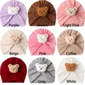 Baby Turban Mützen in neun Farben mit niedlichen Plüschbär-Aufnähern aus Strickstoff - Einheitsgröße / 9 Farben Mix