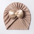 Détail du bonnet pour bébé en tricot kaki orné d'un grand nœud en satin et bouton - Café