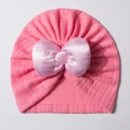 Détail du bonnet turban rose pour bébé avec un grand nœud en satin et maille chevronnée - Rose