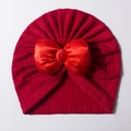 Gros plan détaillé d'un bonnet turban pour bébé rouge avec un grand nœud en satin - Rouge