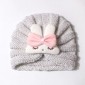 Dettaglio del cappello a turbante per neonati con toppa a coniglietto e fiocco di raso - Beige