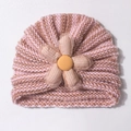 Detail of baby knitted hat featuring pink striped texture and large decorative fabric flower - Coffee
