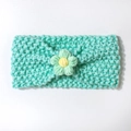 Macro detail of hand-knitted baby headband with mint green yarn and yellow flower accent - Mint Green