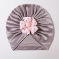 Detailed view of grey velvet baby turban hat with a large red polka dot fabric flower - Gray