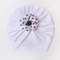 Detail of baby velvet turban hat showing polka dot flower and soft pleated fabric - White