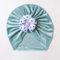 Detailed macro view of mint green velvet baby turban hat with a floral fabric ornament - Mint Green
