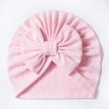 Detailaufnahme der rosa Waffelstruktur-Babymütze mit einer großen, süßen Schleife - Rosa