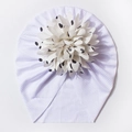 Detail einer weißen Rippstrick-Babymütze mit großer 3D-Blume und schwarzen Punkten - Weiß