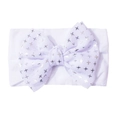Detail of white nylon baby headband featuring a large bow with silver star print patterns - White